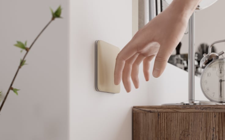Main approchant un interrupteur Ajax LightSwitch intégré au mur